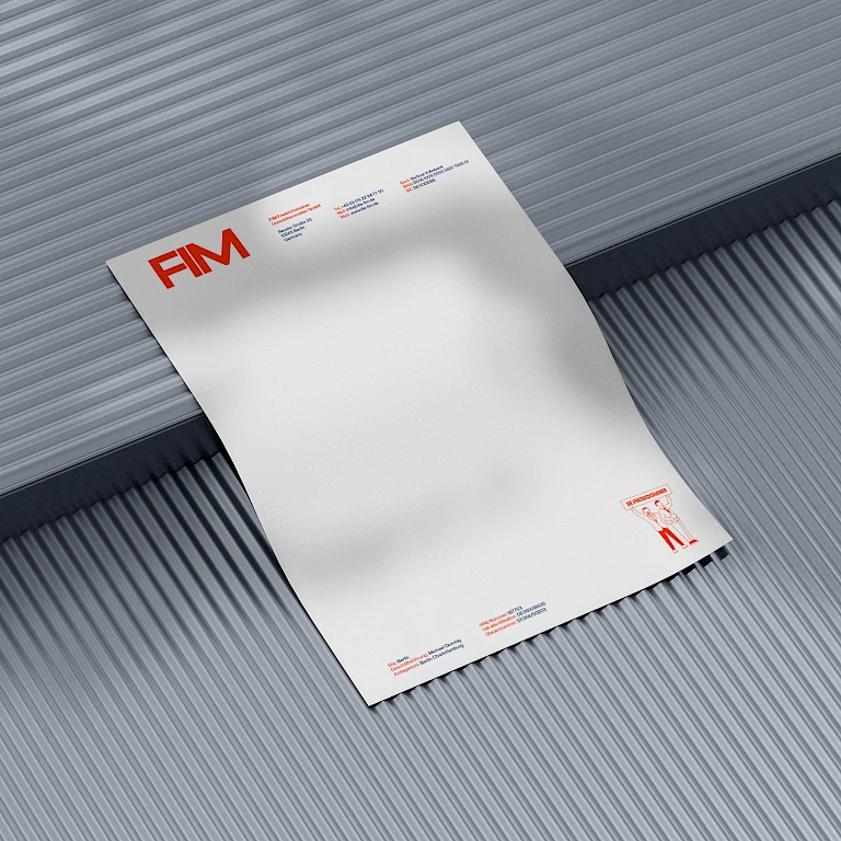 Ein Briefpapier der FIM GmbH, gestaltet von passing bird liegt auf einem grauen Hintergrund.