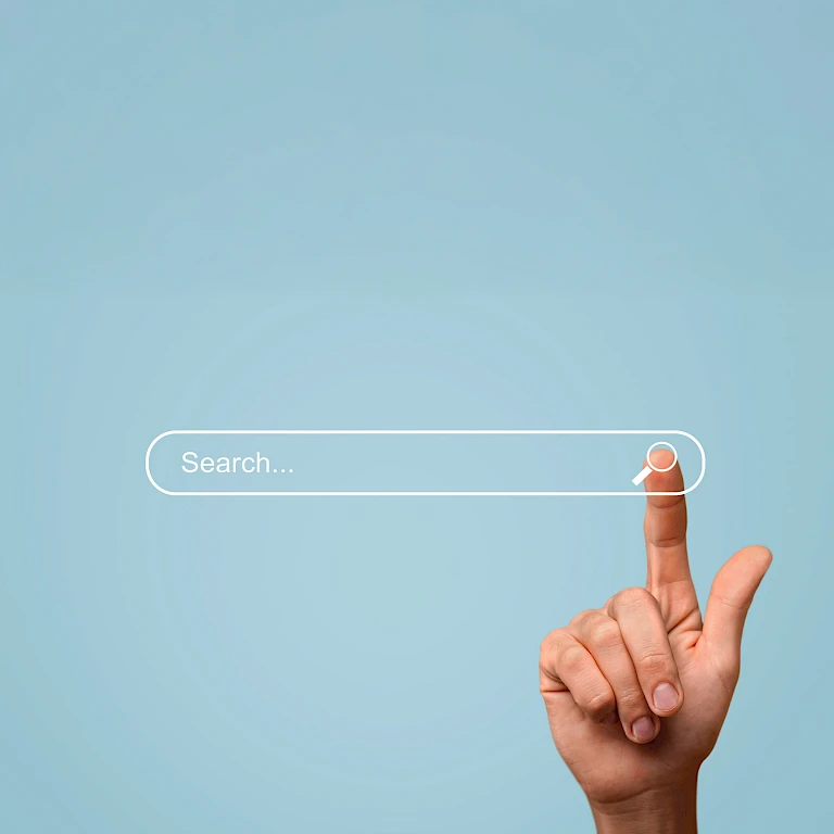 Eine Hand, die auf eine Suchleiste tippt vor blauem Hintergrund.