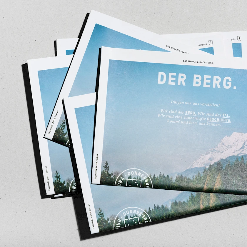 Ein Stapel der Zeitung Berg und Tal des Tourismusverbandes Grimming-Donnerbachstal von passing bird.